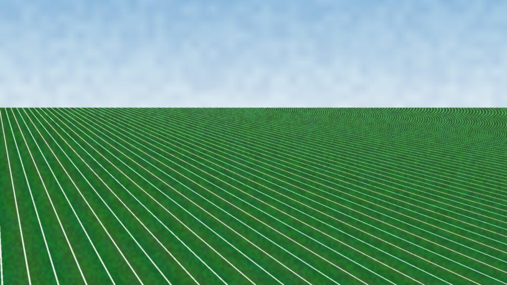 Empty green football field with white yard lines under a pale blue sky