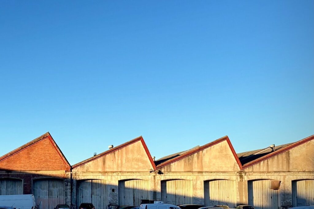 Row of industrial warehouse buildings with red roofs